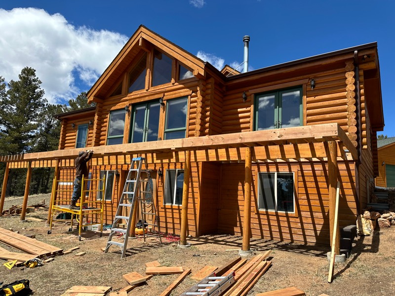 MLP Home Pros carpenter setting pergola rafters on a log home in the pines