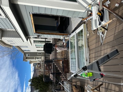 Old patio slider removed and laid on a deck while the opening is prepped