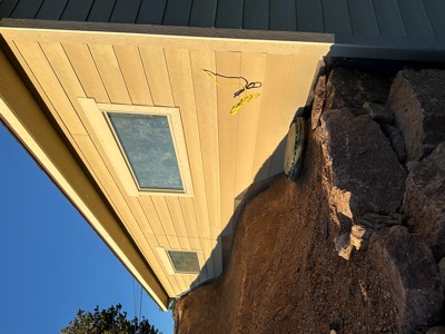 Stone retaining wall and graded slope beside a building foundation