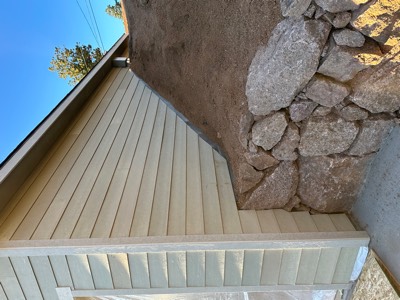 Dry-stacked granite retaining wall alongside a newly sided building